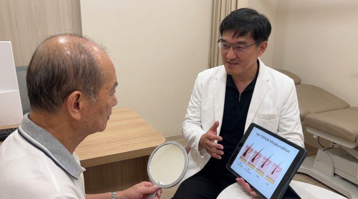 吳紹琥醫師說明落髮治療中的再生醫學應用 男性進行頭皮檢測評估落髮治療效果 顯微鏡下觀察毛囊受落髮治療活化過程 專業醫師操作PRP生長因子落髮治療